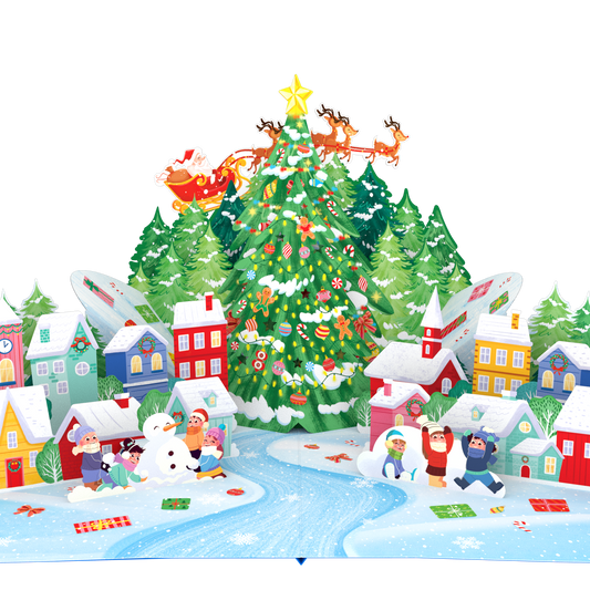A colorful 3D pop-up cardboard Christmas village scene with a decorated Christmas tree, Santa in a sleigh, houses, snow, children, and a winding blue river on a white background.