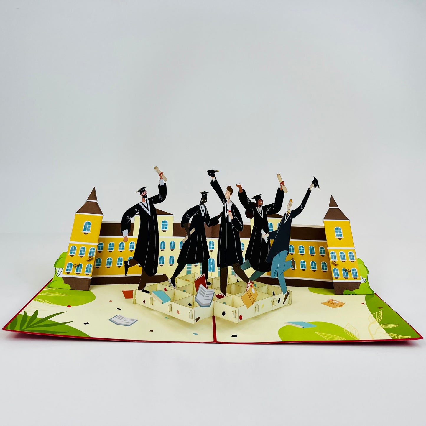 Graduation-themed pop-up card with graduates and a building