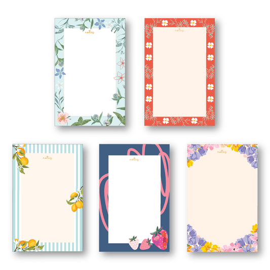 Set of five notepads with floral and fruit designs on a dark background