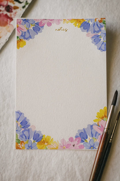 Floral notepad with a pen on a textured surface
