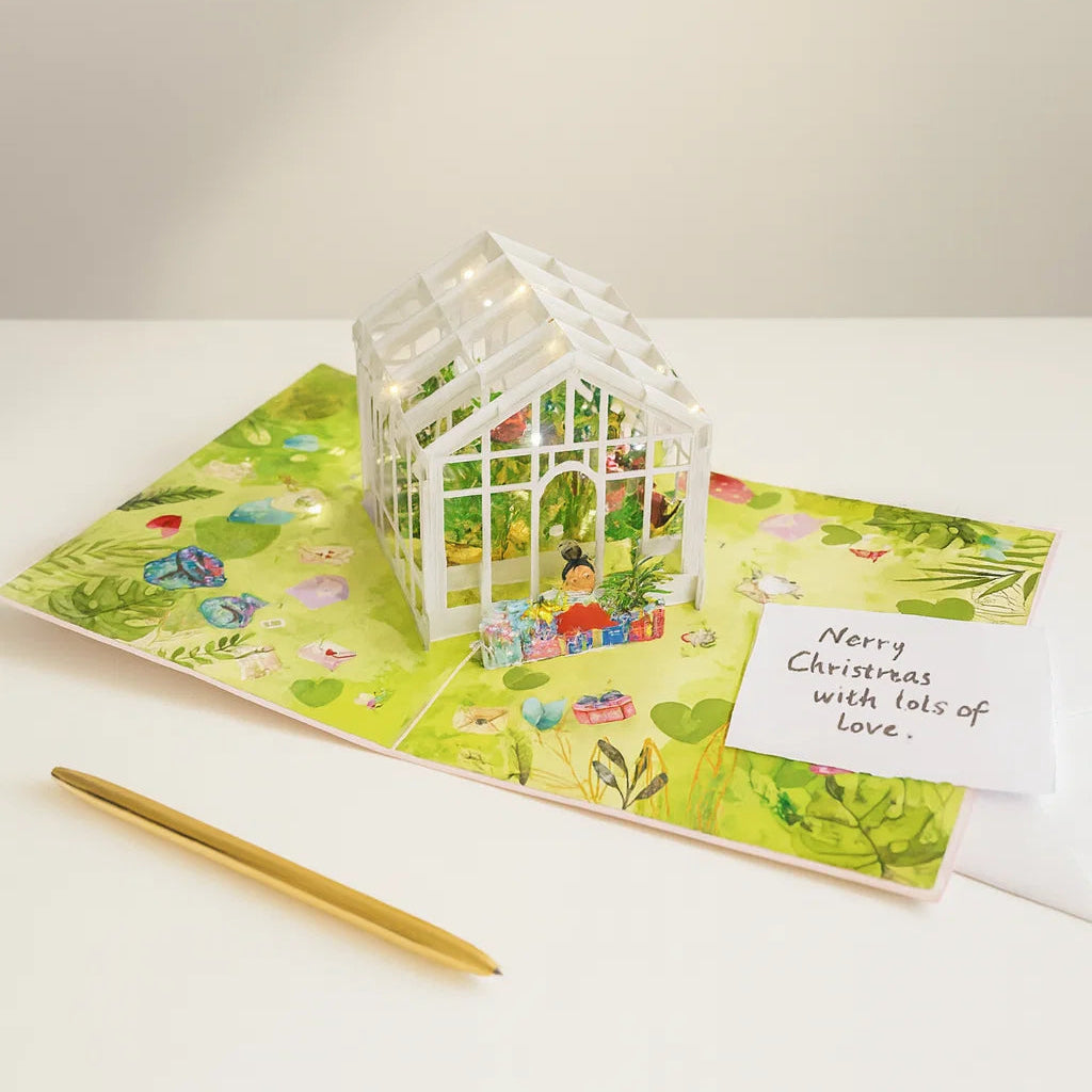 Greeting card with a small white house and pen on a white surface