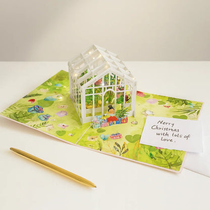 Greeting card with a small white house and pen on a white surface