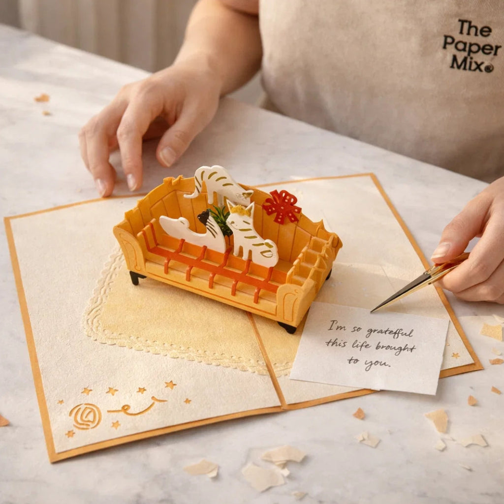 Person holding a 3D paper craft of a waffle with a knife, placed on a greeting card.