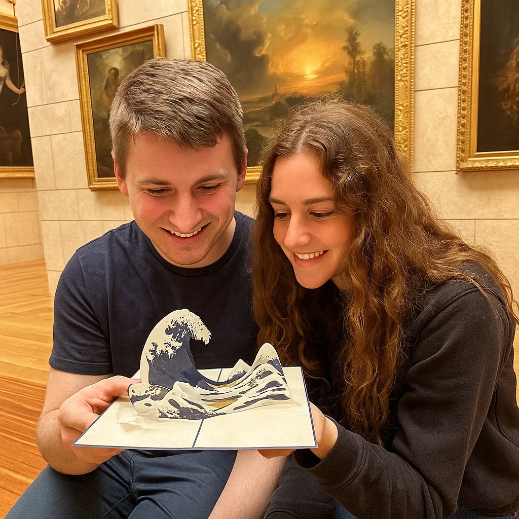 Two people holding a 3D printed model of a wave in a room with framed paintings on the wall.